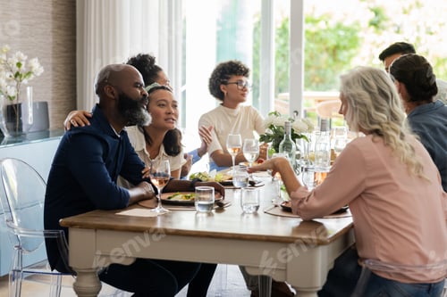 Preview: Friends enjoying joyful conversation and delicious meal at elegant wedding reception