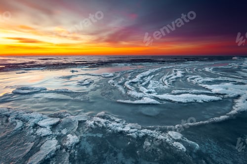 Preview: Bright colorful sunset at the coast of the Baltic Sea in Lithuania with waves swirling around