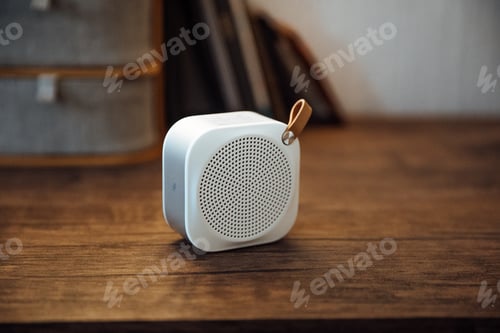 Preview: Selective focus shot of a small white speaker with a brown handle on a wooden surface