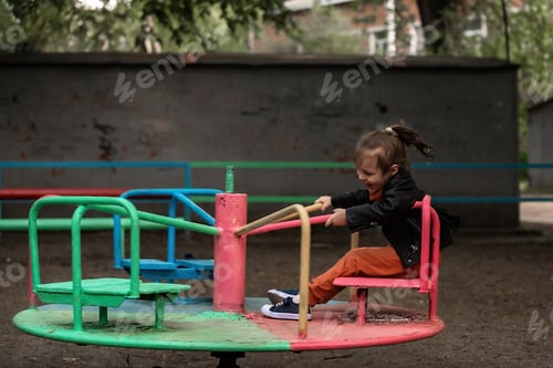 Preview: the child has fun on the playground on a swing