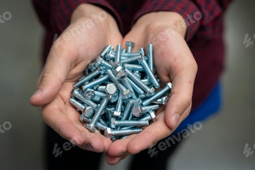 Preview: persons hand hold silver bolts close up concept b