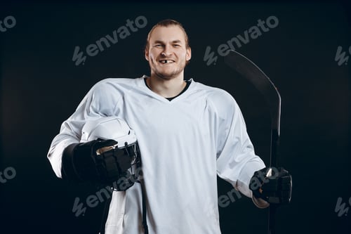 Preview: Handsome hockey player. Smiling at camera isolated on black background.