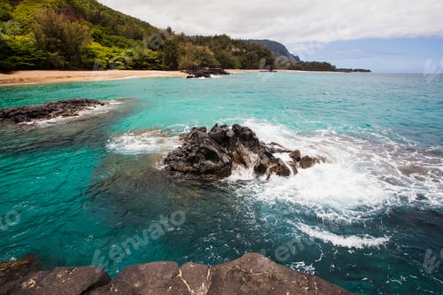 Preview: A bay and headland with rocky shore, sand and turquoise water.