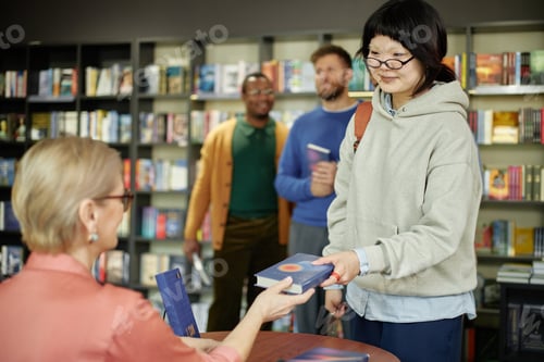 Preview: Young Asian Woman Receiving Book with Autograph from Female Author