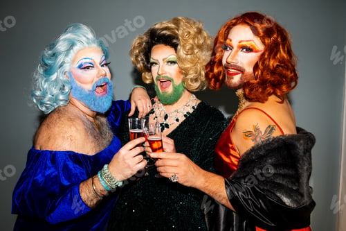 Preview: Three glamorous drag queens toasting with champagne at a festive gathering