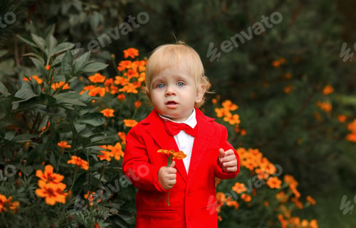 Preview: little boy in a red suit near the flowers. birthday