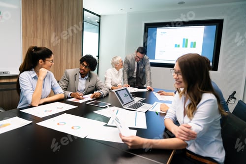 Preview: Group of business partners discussing documents and ideas at meeting