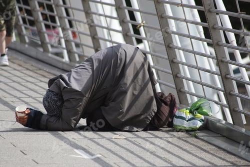 Preview: Person bending on the ground with the head down and asking for alms