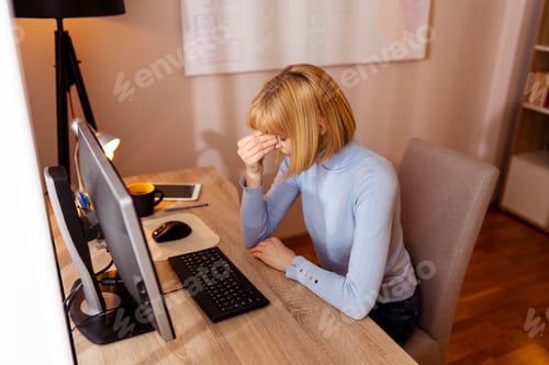 Preview: Woman having a headache while working in an office