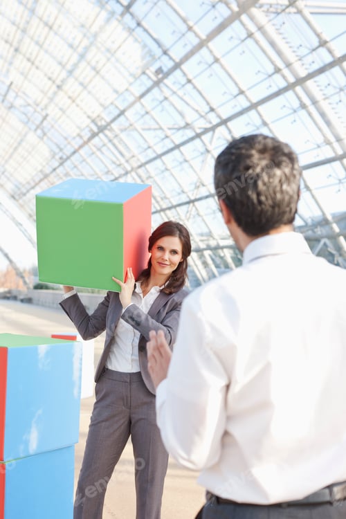 Preview: Germany, Leipzig, Business people playing with cubes