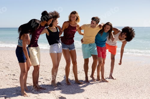 Preview: Multi-ethnic group of male and female standing on the beach