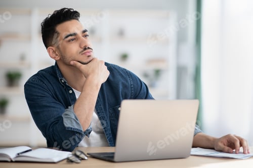Preview: Thoughtful man sitting in office and looking at copy space