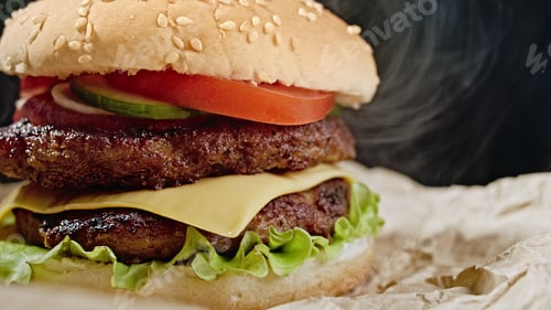 Preview: burger with meat cutlet, onion, vegetables, melted cheese, lettuce and mayonnaise sauce on parchment