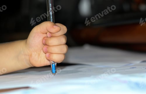 Preview: A small child's hand holding a pen