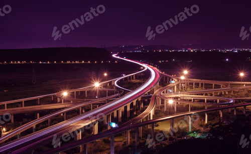 Preview: Long exposure nighttime shot of a long winding road with multiple bridges spanning its length