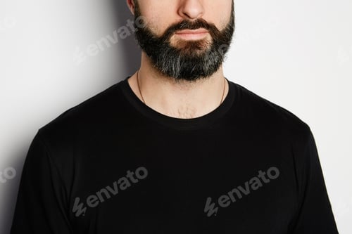 Preview: Portrait of bearded man in black tshirt on the empty background