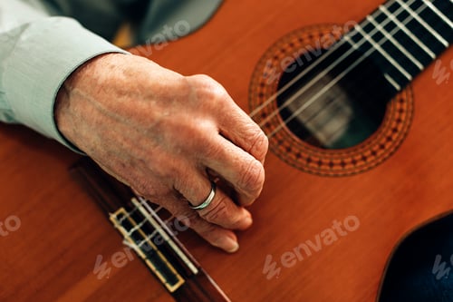 Preview: close up on the hands of an old guitarist playing acoustic guitar