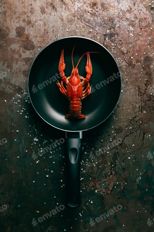 Preview: top view of frying pan with crayfish on grungy tabletop with salt