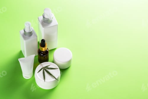 Preview: Cannabis cosmetic products on green background close up.