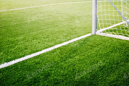Preview: Corner of goalposts on green grass of soccer field, no people