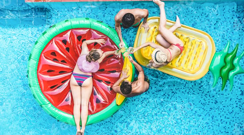 Preview: Happy friends having fun inside swimming pool during summer vacation