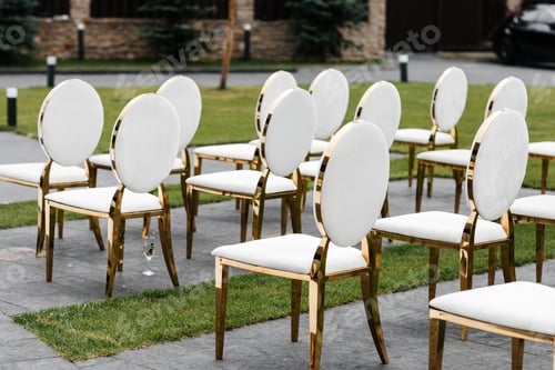 Preview: Luxury white-golden chairs on wedding ceremony outdoors. Festive decorations. Empty rows armchairs f