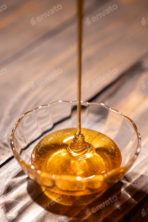 Preview: Fresh floral honey is poured into a glass bowl