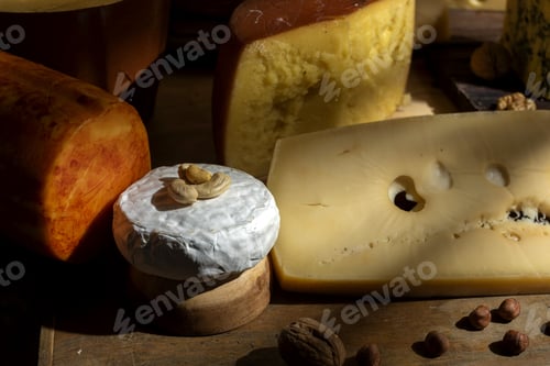 Preview: Closeup shot of a wooden board with a variety of delicious cheeses