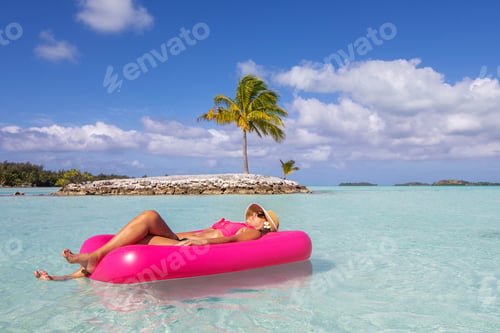 Preview: Woman floating over tropical island turquoise ocean water