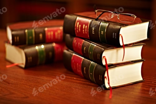 Preview: Shot of a stack of legal books and a pair of glasses on a table in a study