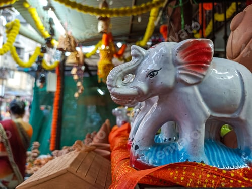 Preview: Ceramic elephant figurine with displayed in a retail store.