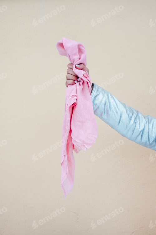 Preview: A woman hand holding the pink scarf. Concept beat cancer