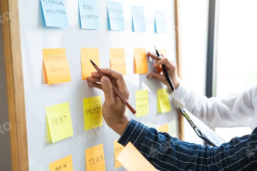 Preview: Two creative business people meeting and planning use post it notes sticky note on desk to share