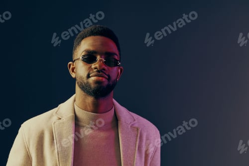 Preview: Confident young man in sunglasses and stylish beige jacket against a colorful gradient background