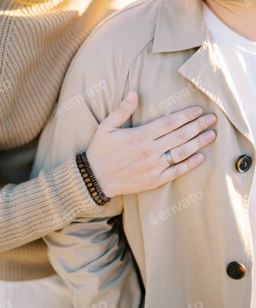 Preview: Man hugs his partner from behind with his hand on his chest. Cropped. Faceless