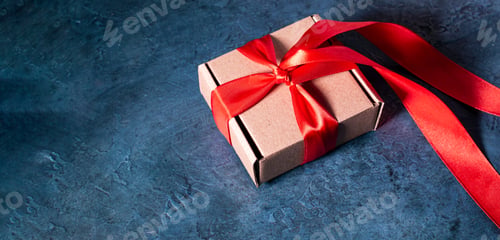 Preview: christmas gift box with red ribbon on blue background