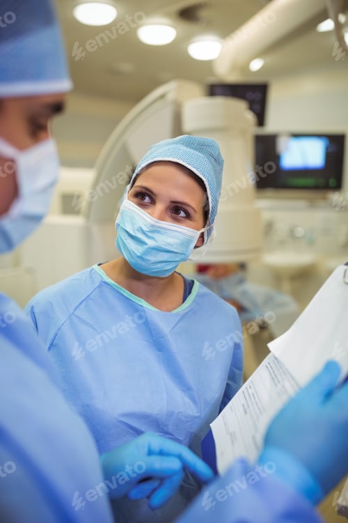 Preview: Surgeons Reviewing Medical Chart in Operating Room