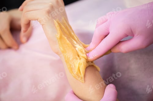 Preview: Beautician makes a sugaring for a young girl, she sharply tears the sugar paste from her hand
