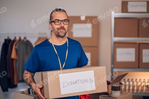 Preview: Portrait of a man volunteer working in a charity donation center
