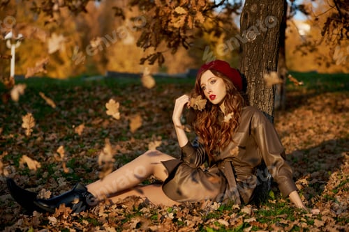 Preview: Autumn portrait of a woman in a hat beret and raincoat near a tree in autumn yellow foliage