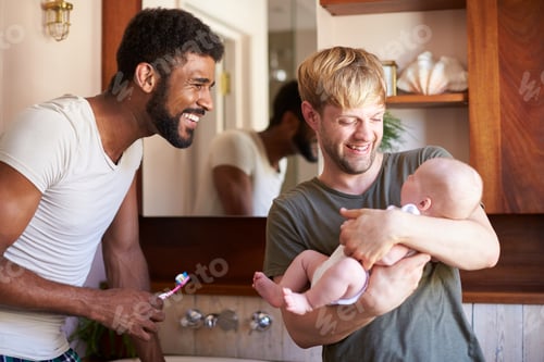 Preview: Loving Male Same Sex Couple Cuddling Baby Daughter In Bathroom At Home Together