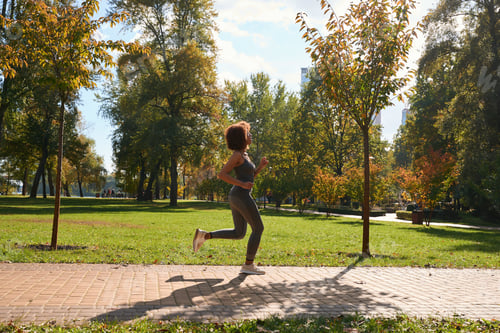 Preview: Determined female athlete running outdoors in morning