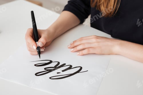 Preview: Close up photo of young woman hands writing on paper on desk isolated