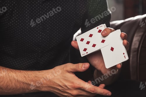 Preview: Close-up clever hands of magician with gambling cards
