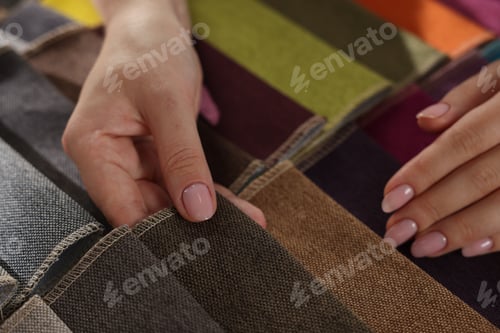 Preview: Woman choosing fabric among different samples indoors, closeup