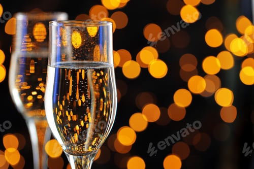 Preview: Two glasses of Champagne against bokeh lights background