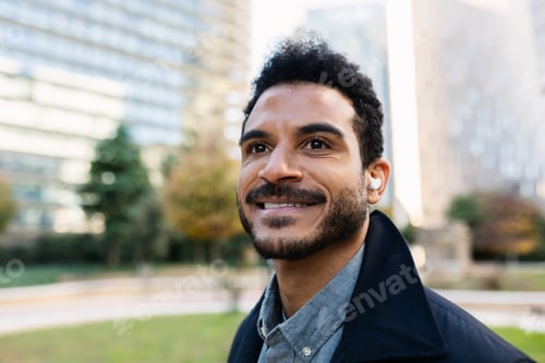 Preview: Young adult Latin American businessman smiling outdoors