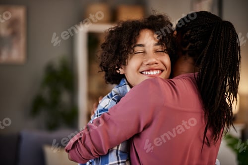 Preview: A boy hugging his caring mother while standing in the living room at home.
