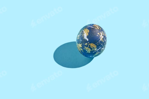 Preview: Blue and gold earth-inspired sphere on light blue background with shadow