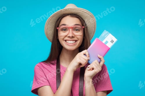 Preview: Excited young woman tourist with beautiful smile holding passport with tickets